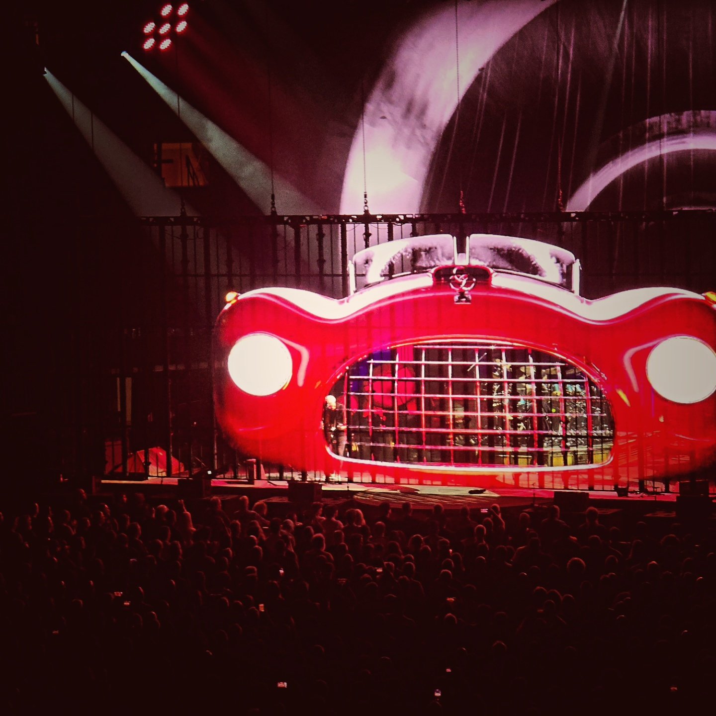 A concert stage built as a giant red car with the band playing inside it