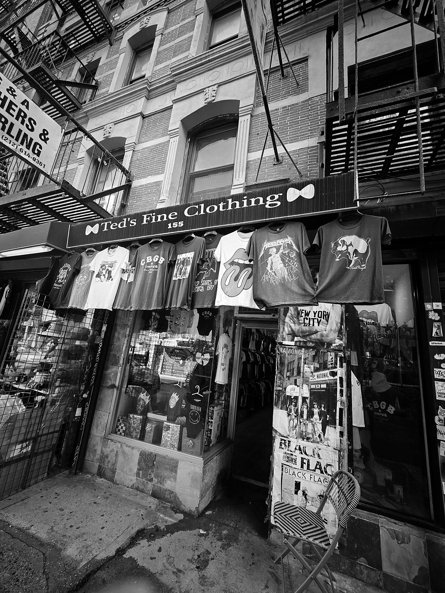 Storefront of Ted’s Fine Clothing with rock band t-shirts hanging above the door